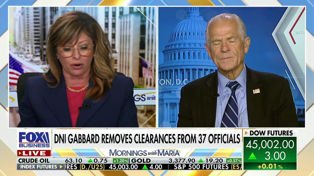 The woman on the left is speaking, her mouth open, while a man on the right listens with his eyes closed. The Fox Business Network logo is visible, along with a ticker displaying financial data.
