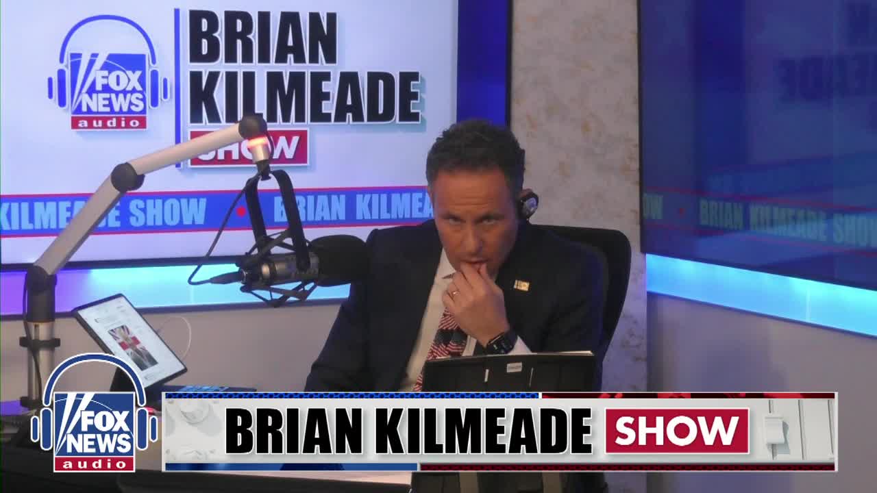 Brian Kilmeade, host of the Fox News Radio show, leans forward, his hand touching his mouth. The studio backdrop displays "BRIAN KILMEADE SHOW" in bold lettering.