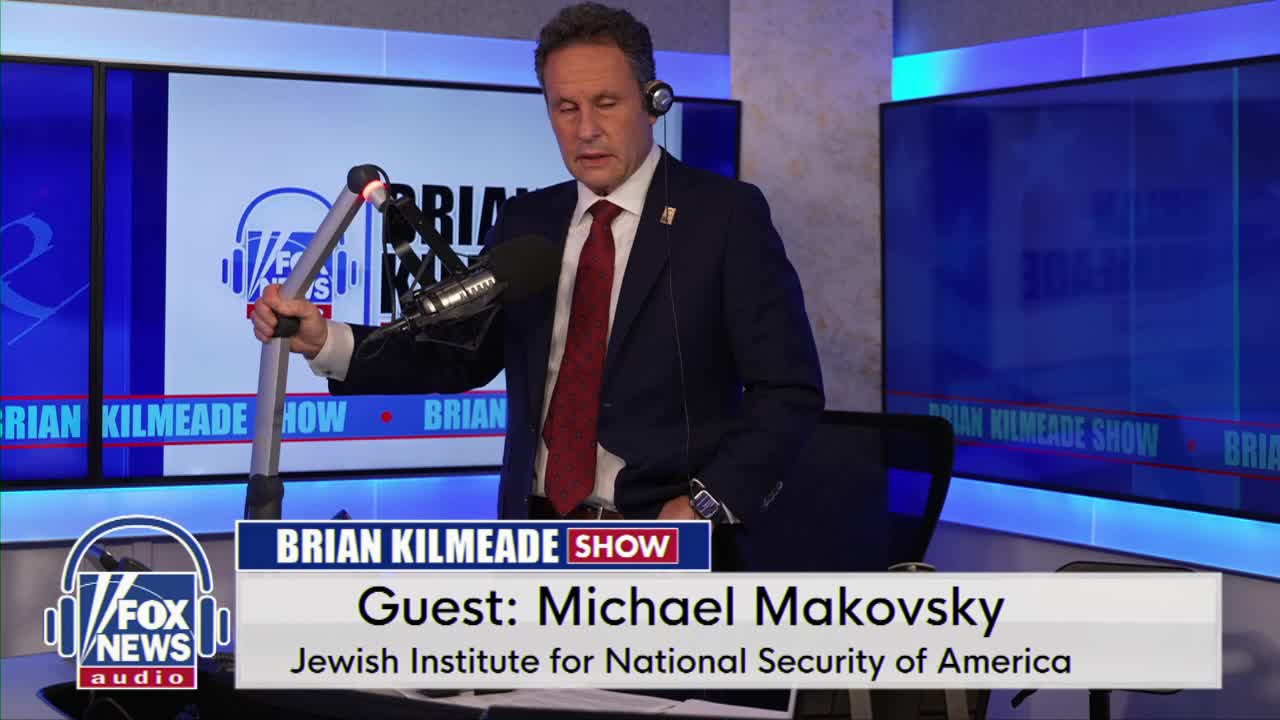 The man in the suit adjusts a microphone stand, his expression focused. A graphic identifies him as Michael Makovsky, a guest on the Brian Kilmeade Show.