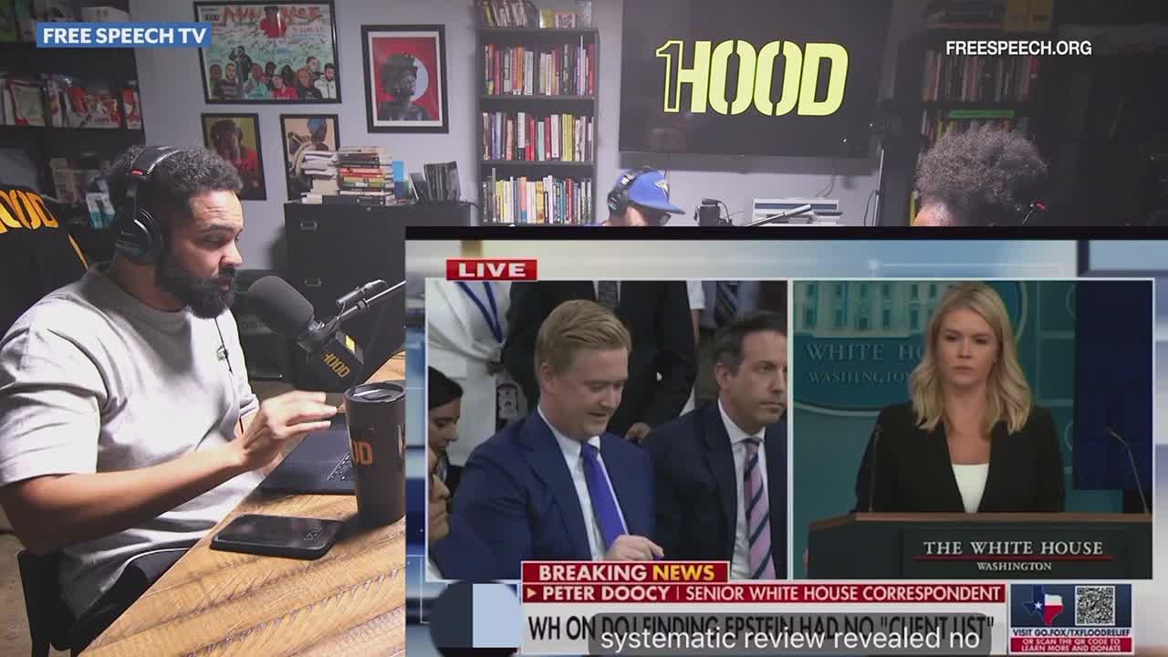 A man with a beard gestures while speaking into a microphone, reacting to a "Breaking News" segment on Free Speech TV. The on-screen coverage shows a White House briefing with Peter Doocy and a woman at a podium.
