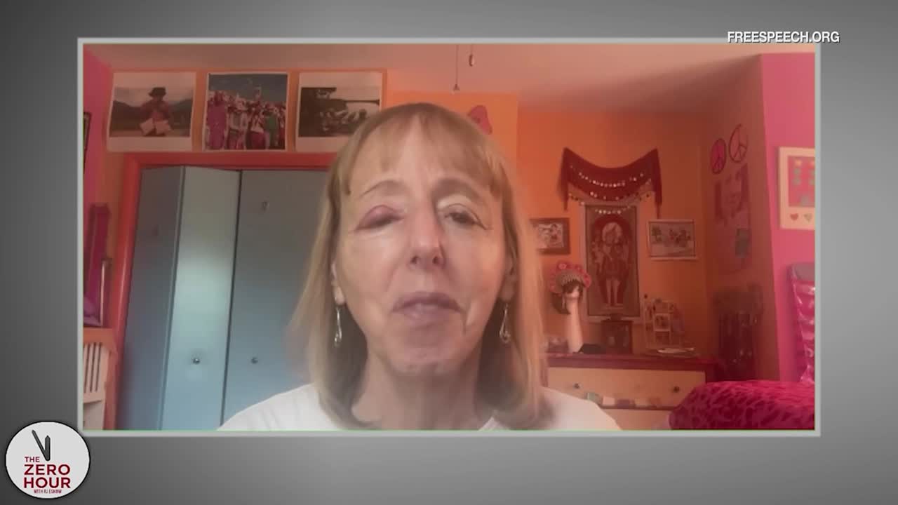 A woman with blonde hair is speaking directly to the camera, framed by a brightly decorated room. The Free Speech TV logo is visible, along with the words "The Zero Hour."
