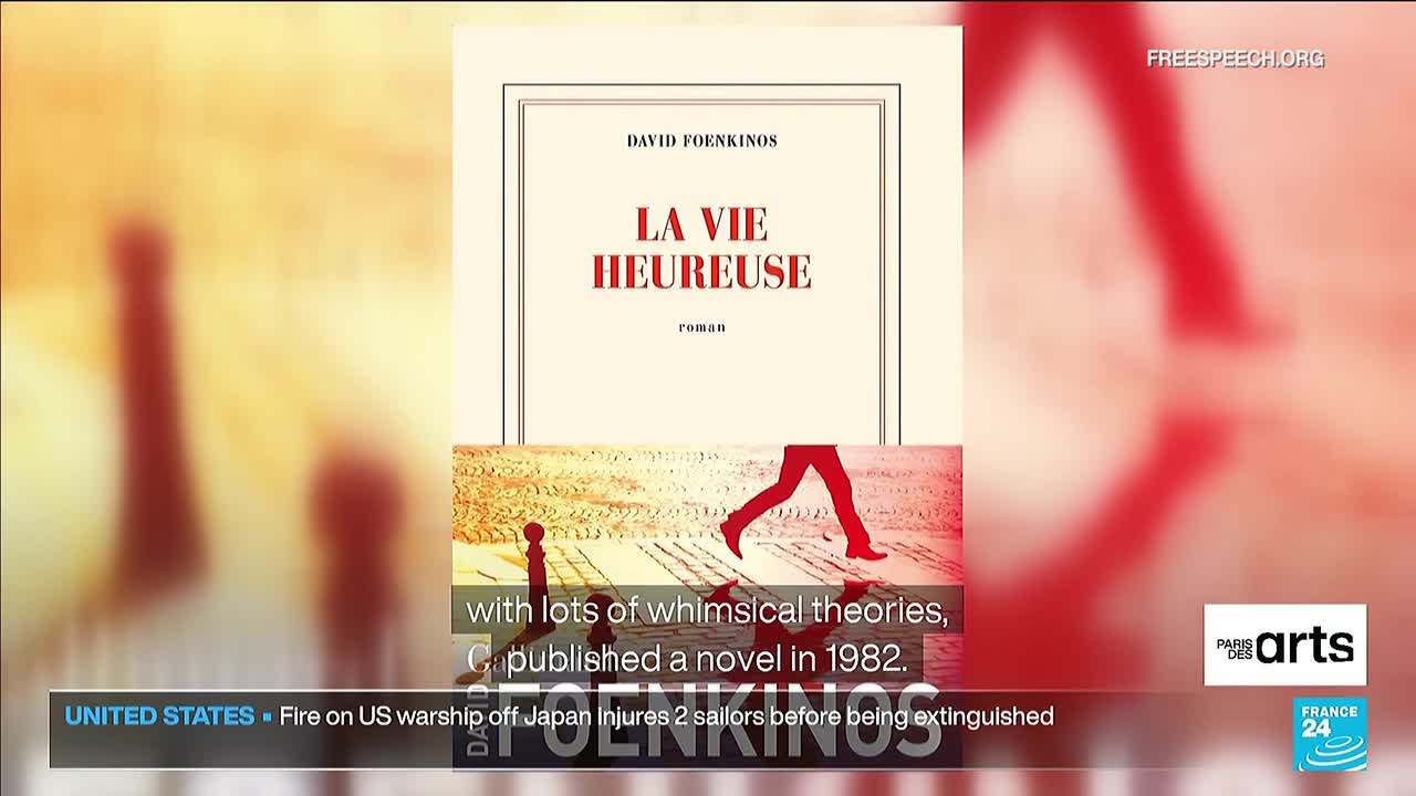 A book cover with the title "La Vie Heureuse" is centered on the screen, with a silhouetted figure walking across a street. Below, a news ticker from Free Speech TV reports on a fire aboard a US warship.
