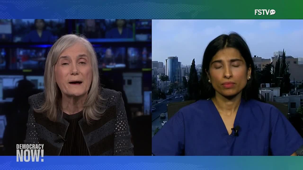 On Free Speech TV, the host of *Democracy Now!* is speaking, while a woman in scrubs appears on a split screen, seemingly from a location with a city view. The woman in scrubs has her eyes closed.
