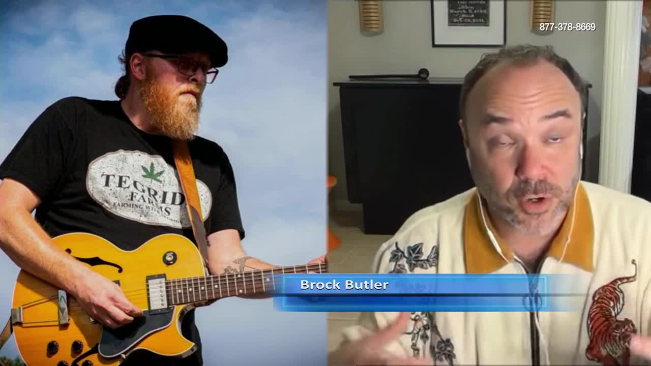A man with a guitar stands against a cloudy sky, while on the right, a man wearing a patterned shirt speaks on a video call. The screen displays the name "Brock Butler" at the bottom.
