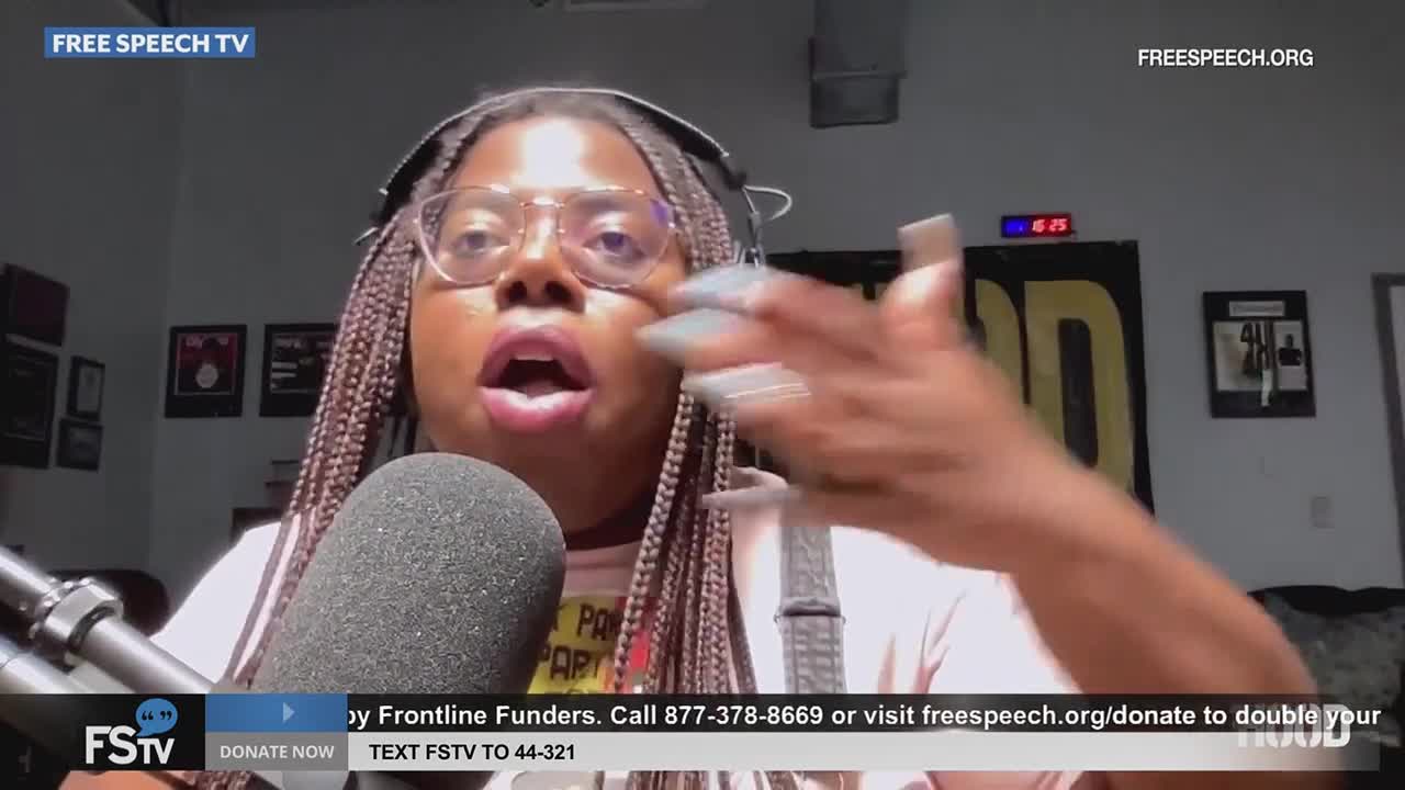 A woman with long braids and glasses gestures emphatically while speaking into a microphone. The Free Speech TV logo is visible in the corner.
