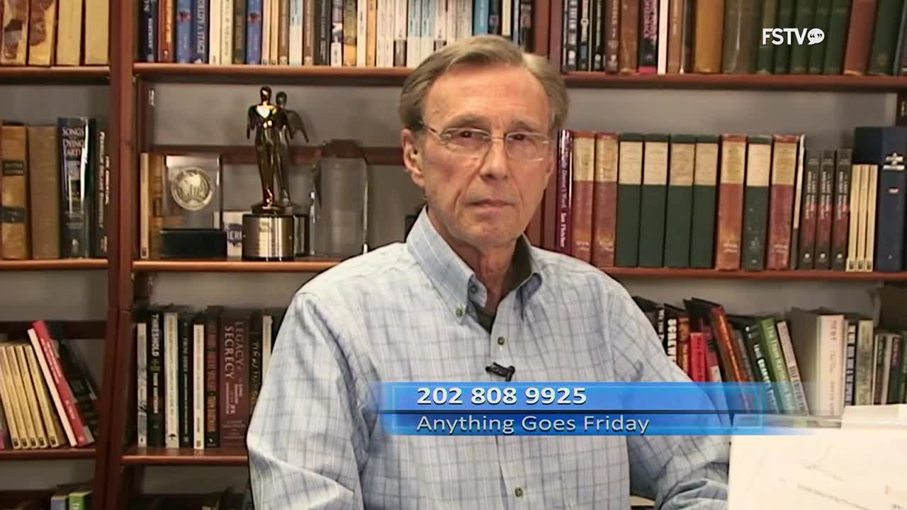 A man with glasses stands in front of bookshelves, a phone number and program title displayed on a blue banner across his chest. The FSTV logo is visible in the upper right corner.