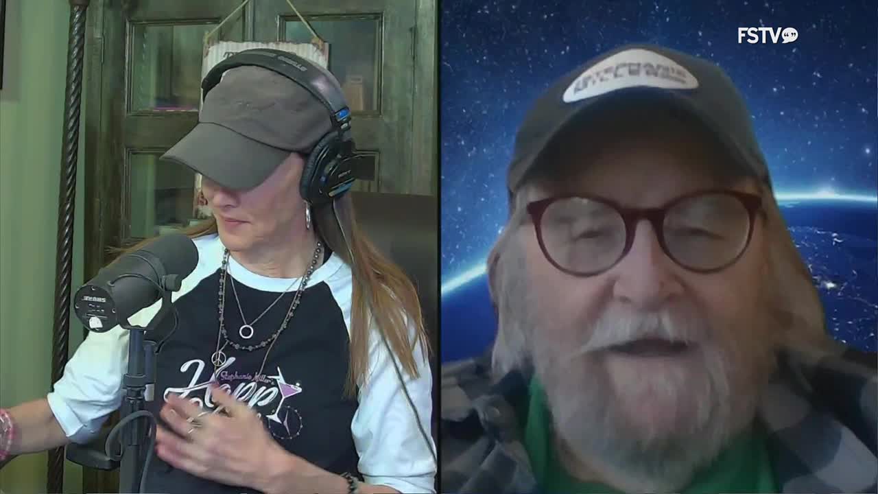 A woman with headphones on leans into a microphone, her long hair falling over her shoulder. To her right, a man with a beard and glasses speaks, his background a swirling image of Earth from space, a common sight on Free Speech TV.