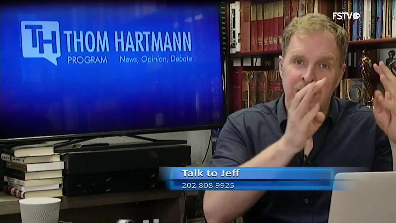 A man gestures animatedly in front of a screen displaying "Thom Hartmann Program." A lower banner reads "Talk to Jeff" with a phone number.