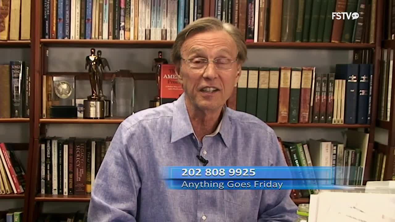 A man in a blue shirt speaks from behind a desk, with bookshelves full of books behind him. A graphic at the bottom of the screen displays a phone number and the words "Anything Goes Friday."