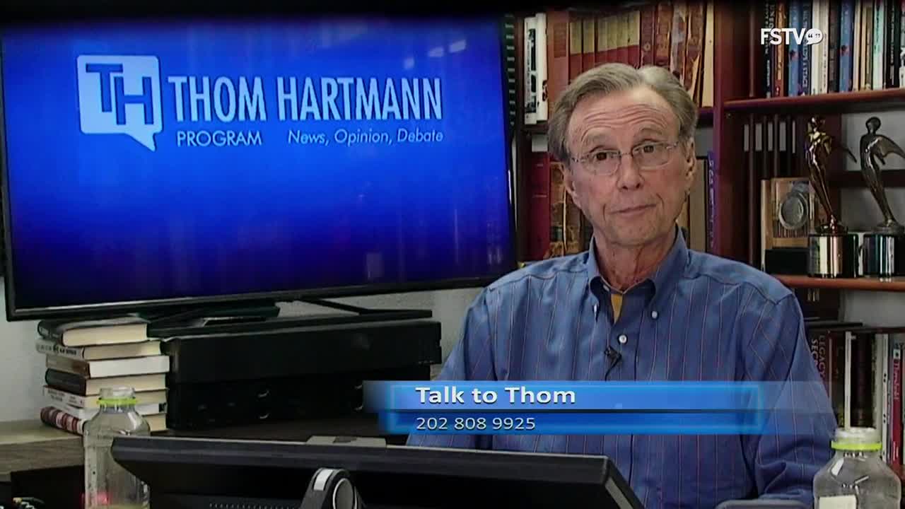 Thom Hartmann sits in his studio, a blue screen behind him displaying the "Thom Hartmann Program" logo. A graphic overlay announces "Talk to Thom" with a phone number.