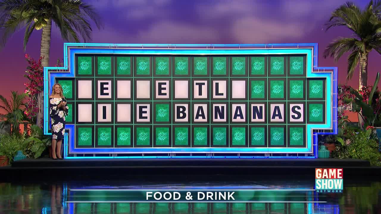 The host, in a floral dress, stands beside the puzzle board, which displays the partially revealed phrase "EAT LIKE BANANAS." The Game Show Network logo is visible, and the category is "FOOD & DRINK."
