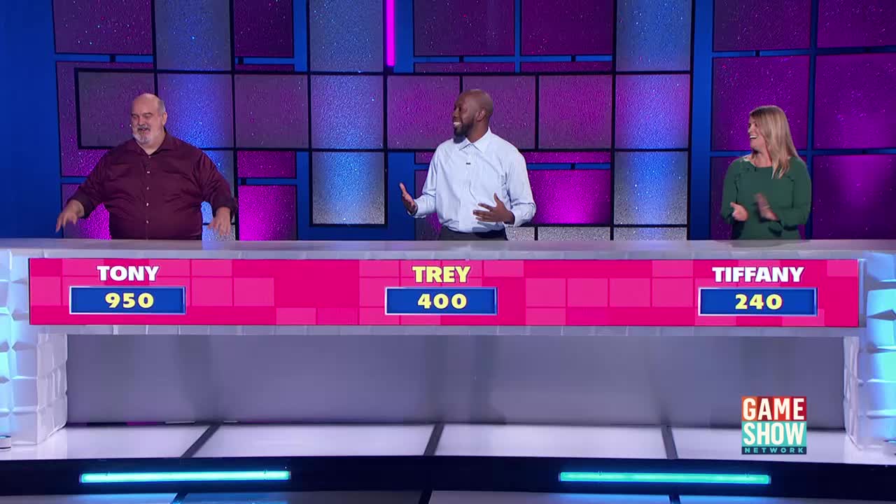 Tony, Trey, and Tiffany stand behind a long podium, each with their names and scores displayed. Trey gestures with both hands as Tiffany claps, while Tony has his arms down.

