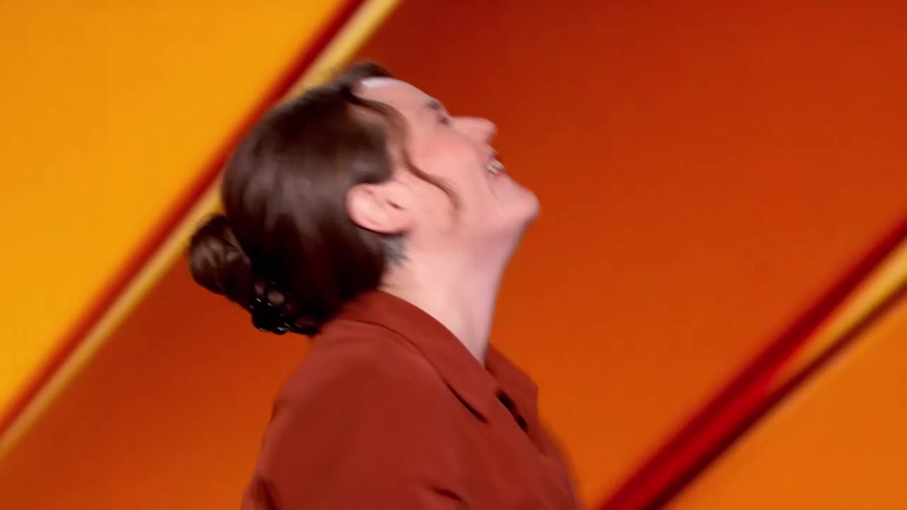 The woman throws her head back, laughing. Her mouth is wide open, and her eyes are closed.
