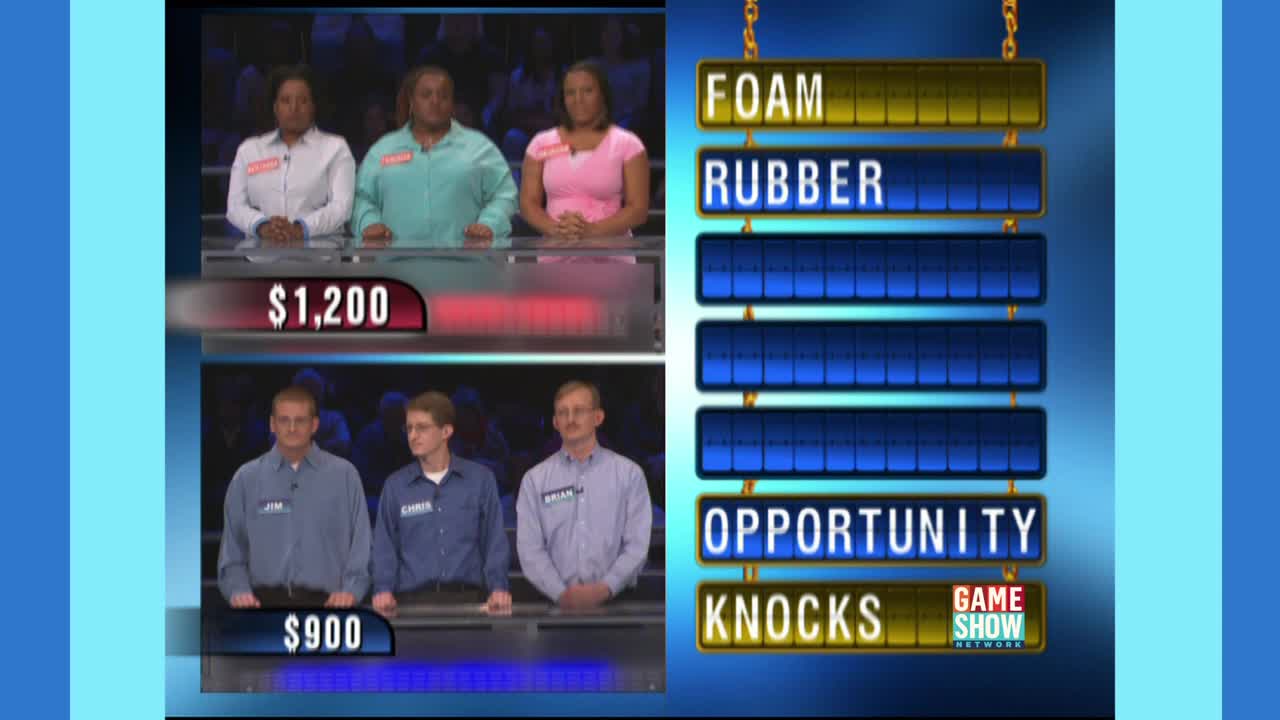 Three women and three men stand behind podiums, facing the camera on a Game Show Network set. The game board displays the partially revealed phrase, "FOAM RUBBER OPPORTUNITY KNOCKS."
