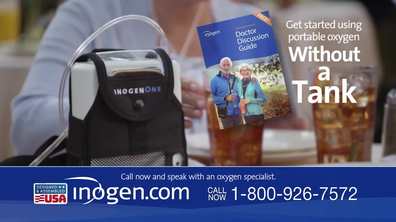 A portable oxygen concentrator sits on a table next to a glass of iced tea. A brochure featuring an older couple is propped up beside it.