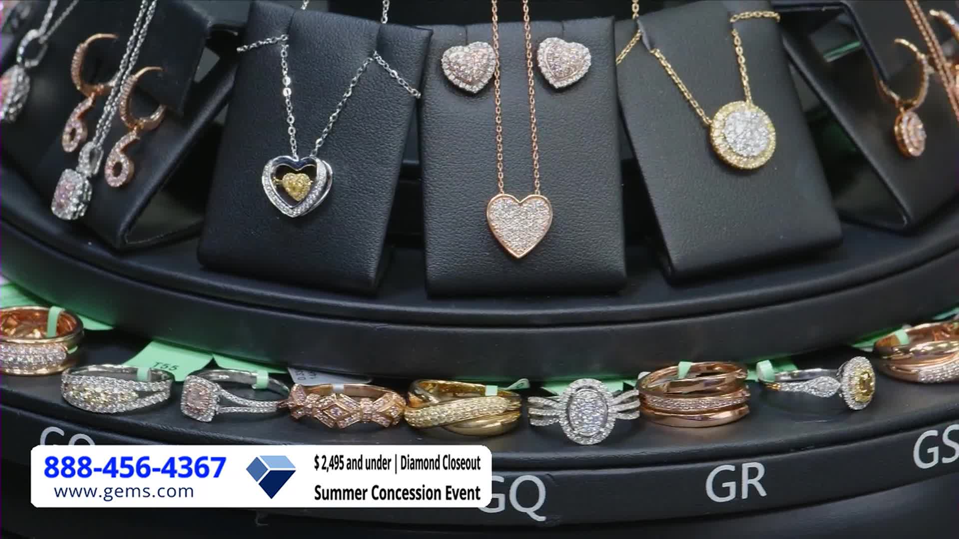 A rotating display shows jewelry, including heart-shaped pendants and rings, all sparkling under bright lights. The Gem Shopping Network's "Diamond Closeout" event is advertised with a phone number and website address at the bottom.

