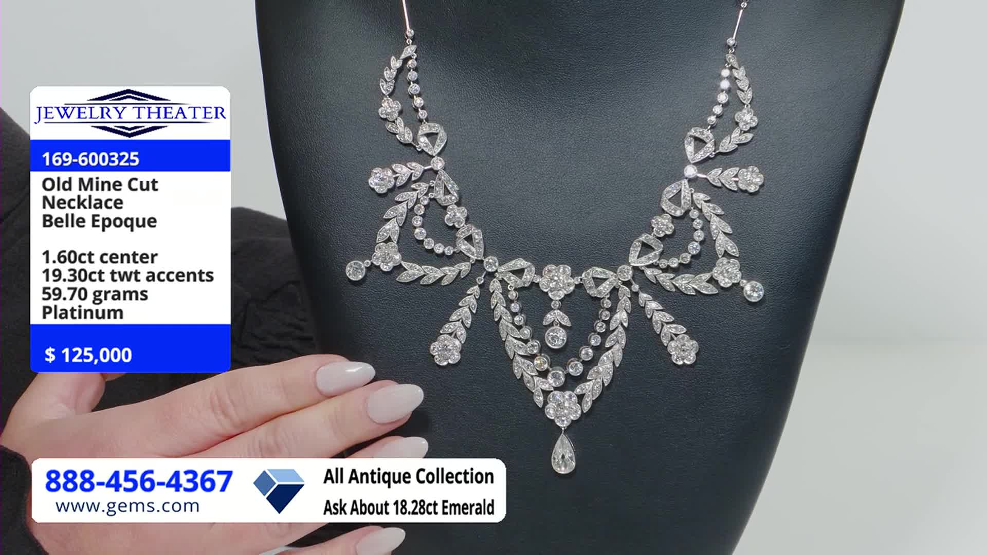 A dazzling diamond necklace is displayed on a black stand, its intricate design catching the light. A hand with manicured nails gently rests beside the jewelry, as the Gem Shopping Network logo and price tag are visible.
