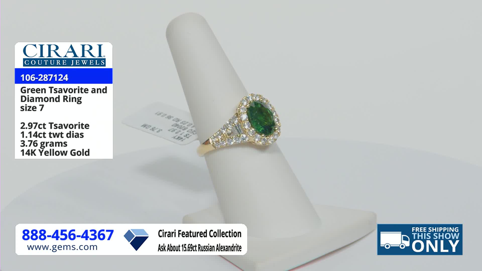 A ring with a large green stone and a halo of diamonds sits on a white display stand. The Gem Shopping Network logo and a phone number are visible in the corner.

