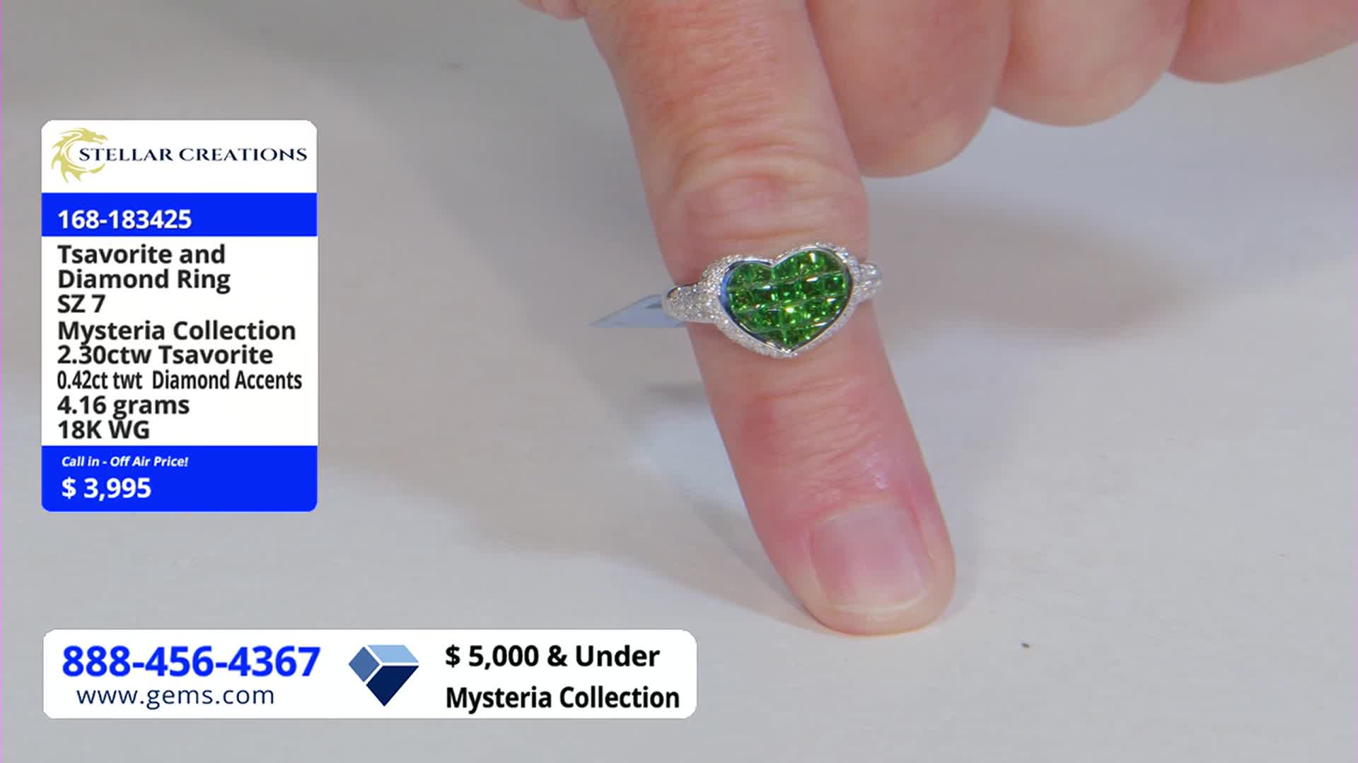 A heart-shaped ring, filled with bright green stones, sits on a finger. The Gem Shopping Network is displaying the ring, with the price and details listed to the left.
