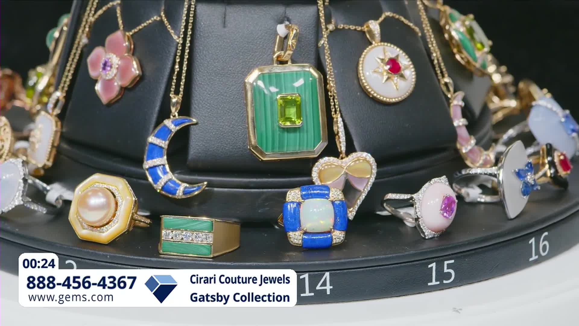 The display rotates, showcasing a collection of necklaces and rings from Cirari Couture Jewels. A bright blue crescent moon pendant with diamond accents catches the light.