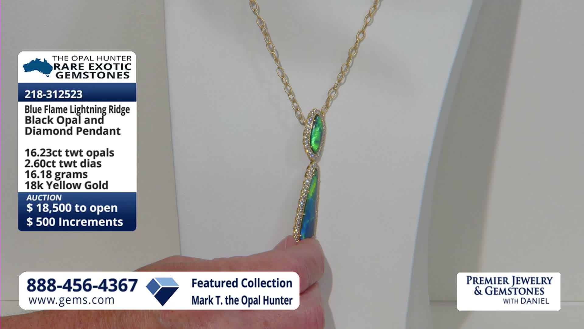 A hand reaches out to adjust a pendant featuring two elongated opals, one above the other, set in yellow gold and surrounded by small diamonds. The pendant hangs from a delicate gold chain, displayed against a white background.