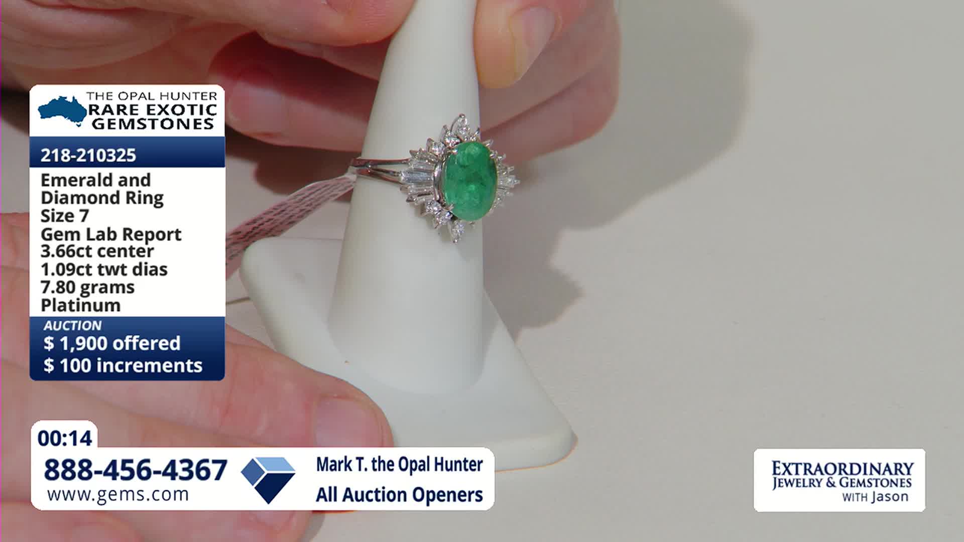 Fingers adjust a platinum ring, its oval emerald surrounded by sparkling diamonds, on a white display stand. A graphic overlay details the ring's specifications and current auction bid.