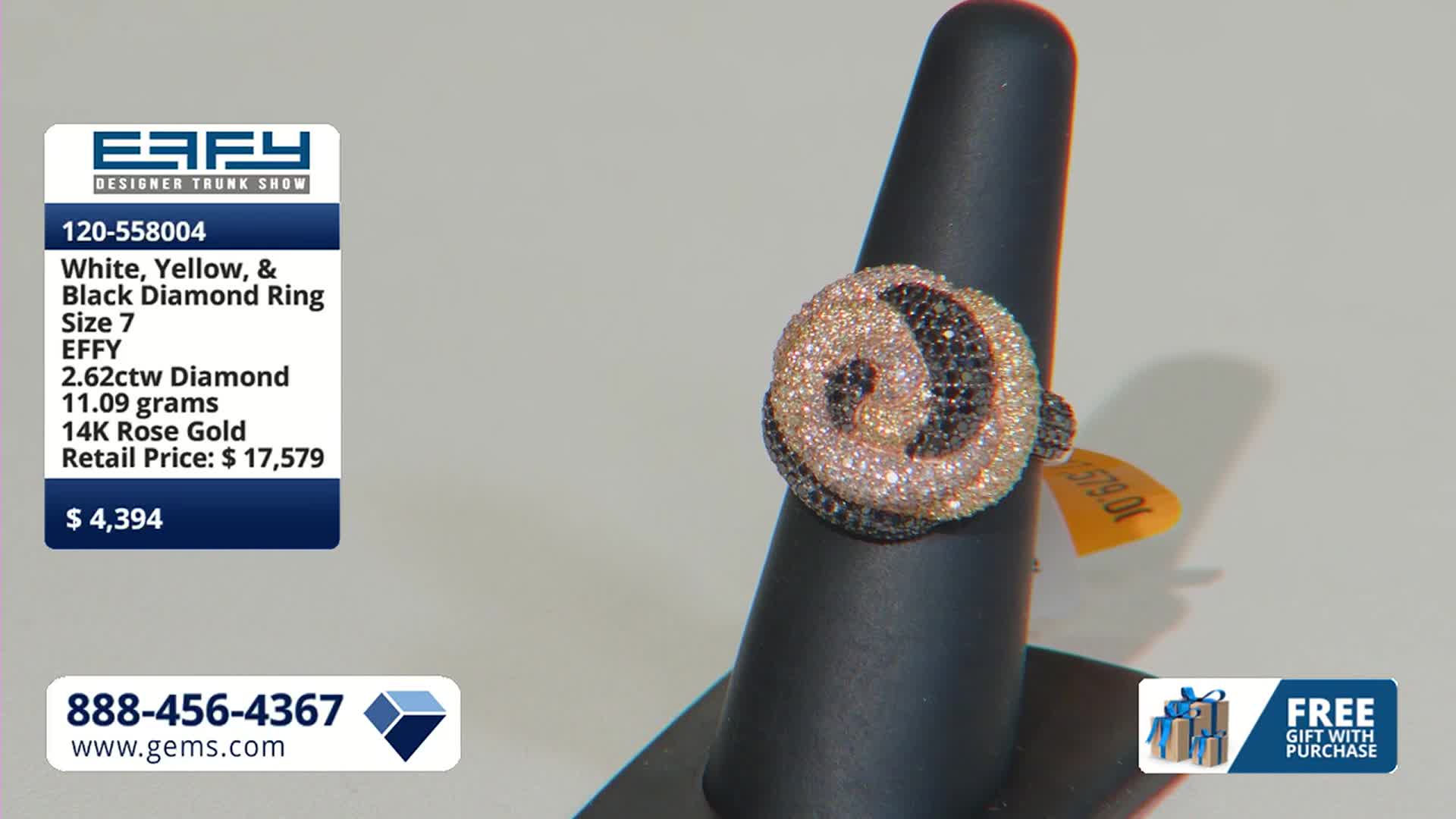 A rose gold ring, encrusted with white, yellow, and black diamonds, sits on a black display. The Gem Shopping Network is offering it for $4,394.