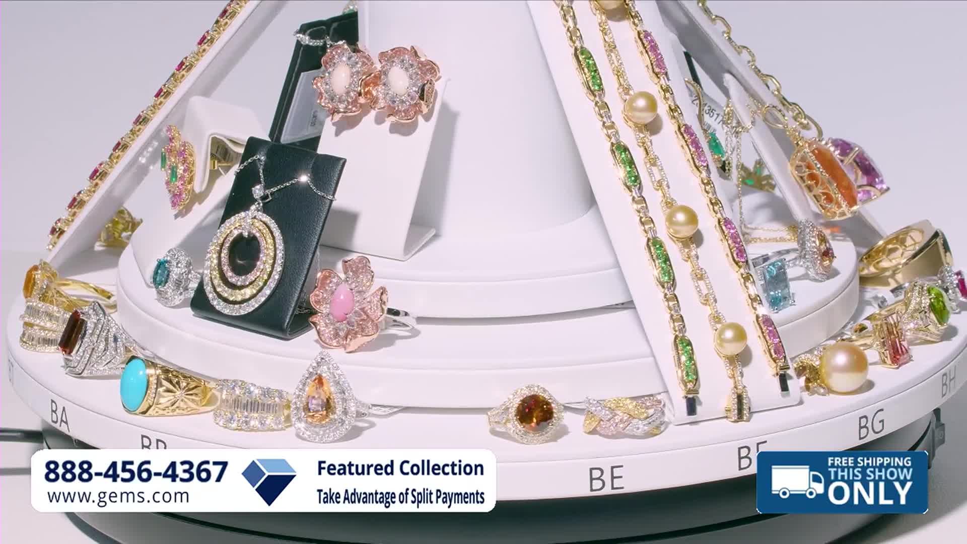 The display rotates, showcasing a variety of sparkling rings and necklaces. A phone number and website for Gem Shopping Network appear at the bottom.