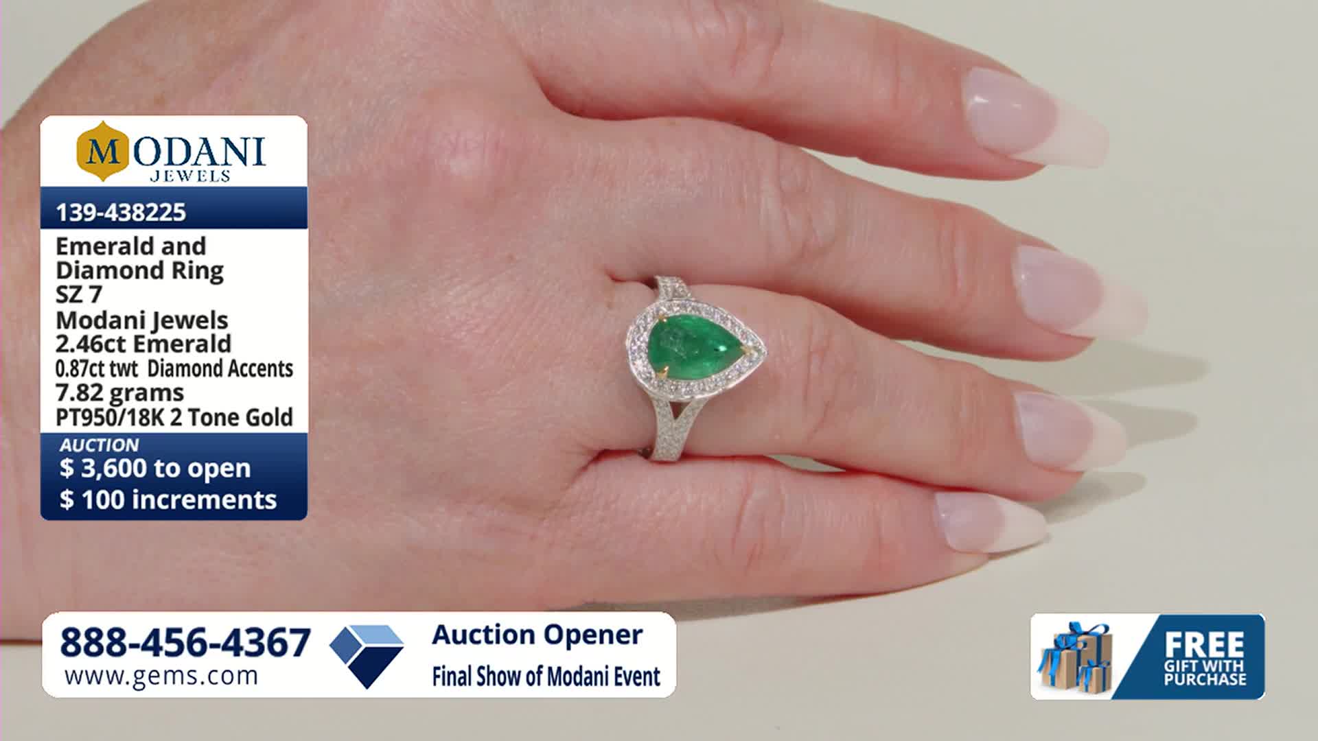 A hand displays a pear-shaped emerald ring surrounded by small diamonds. The ring is part of a Modani Jewels auction, with bidding starting at $3,600.