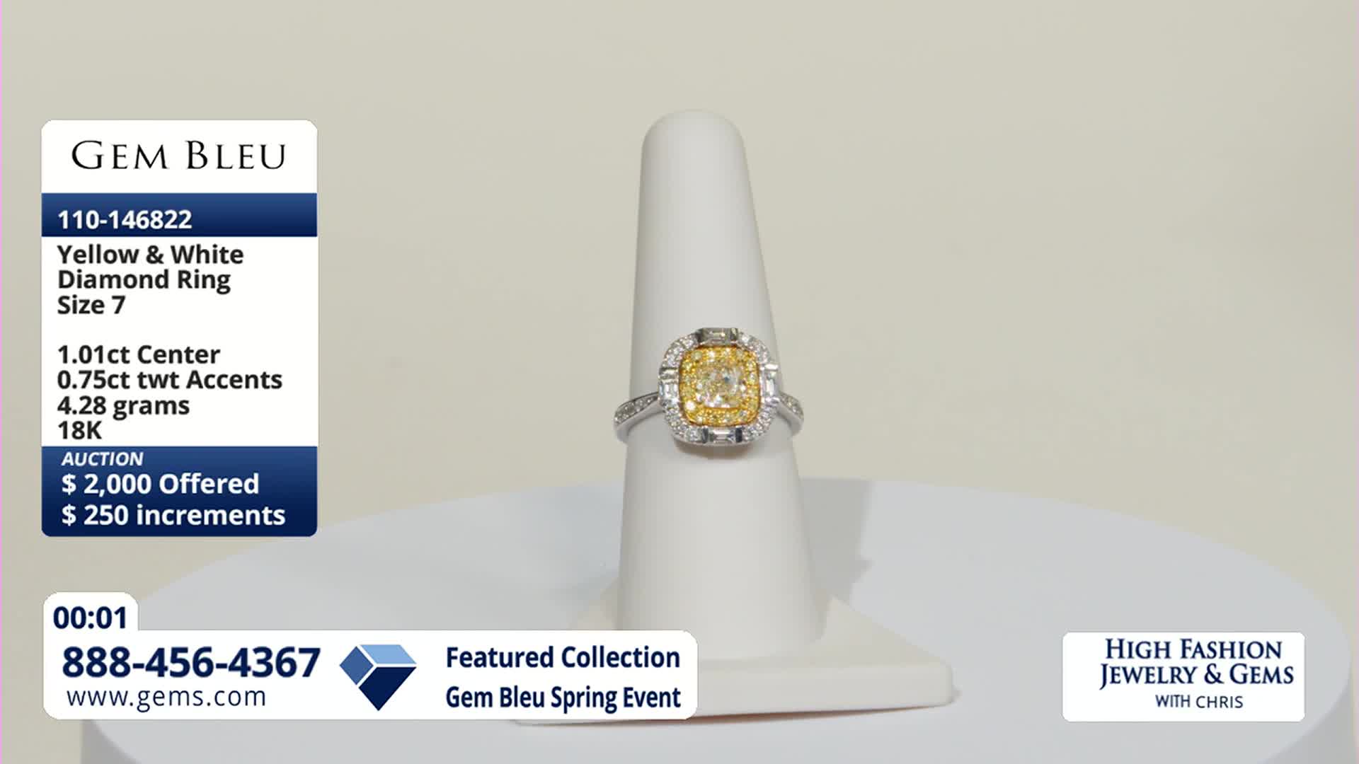 The ring is slowly rotating on its stand. A yellow diamond sits at the center, surrounded by smaller white diamonds.