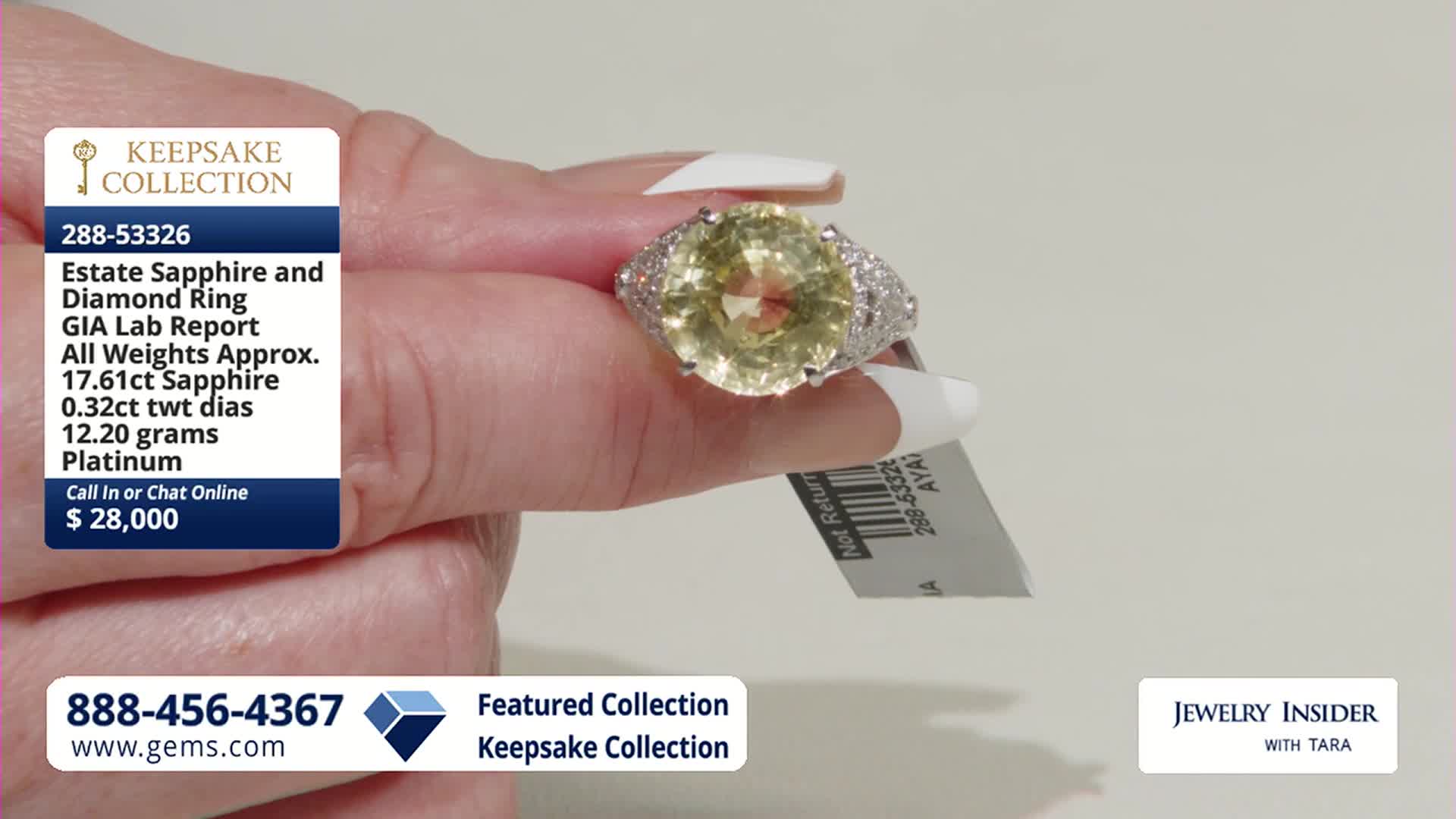 A hand holds up a large, pale yellow sapphire ring, its band encrusted with small diamonds. A white tag with a barcode hangs from the ring's setting.