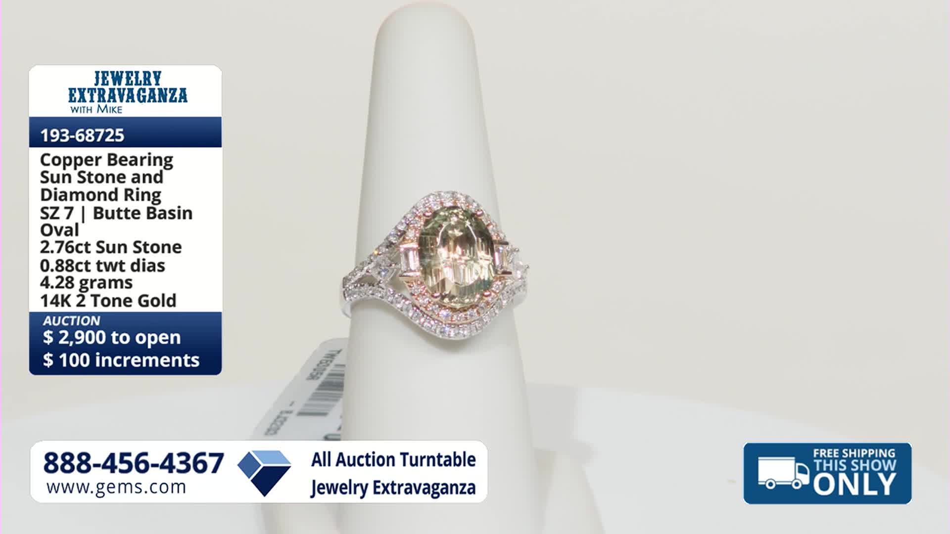 A large oval-cut sunstone, surrounded by white diamonds and smaller pink stones, sits atop a white display. The ring, made of 14K two-tone gold, is currently being showcased on the Gem Shopping Network.