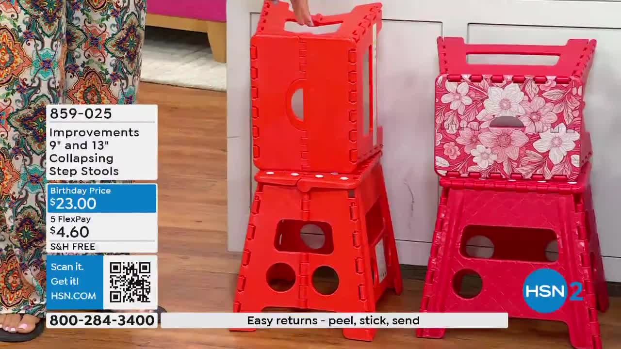 A person is holding a bright red, collapsible step stool, demonstrating how it folds up. Another stool, with a floral pattern on top, sits beside it.
