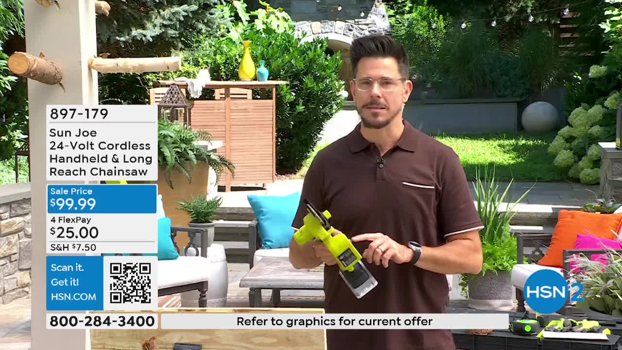 A man in a brown shirt stands outdoors, holding a neon green and black chainsaw. He gestures with it while a graphic on the screen advertises the product on HSN2.
