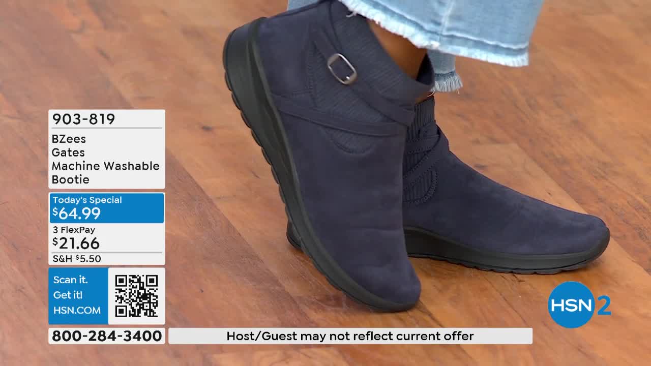 A navy blue bootie is displayed, the ankle-high style featuring a buckle and a small wedge heel. The HSN2 logo and a price tag are visible in the corner of the screen.
