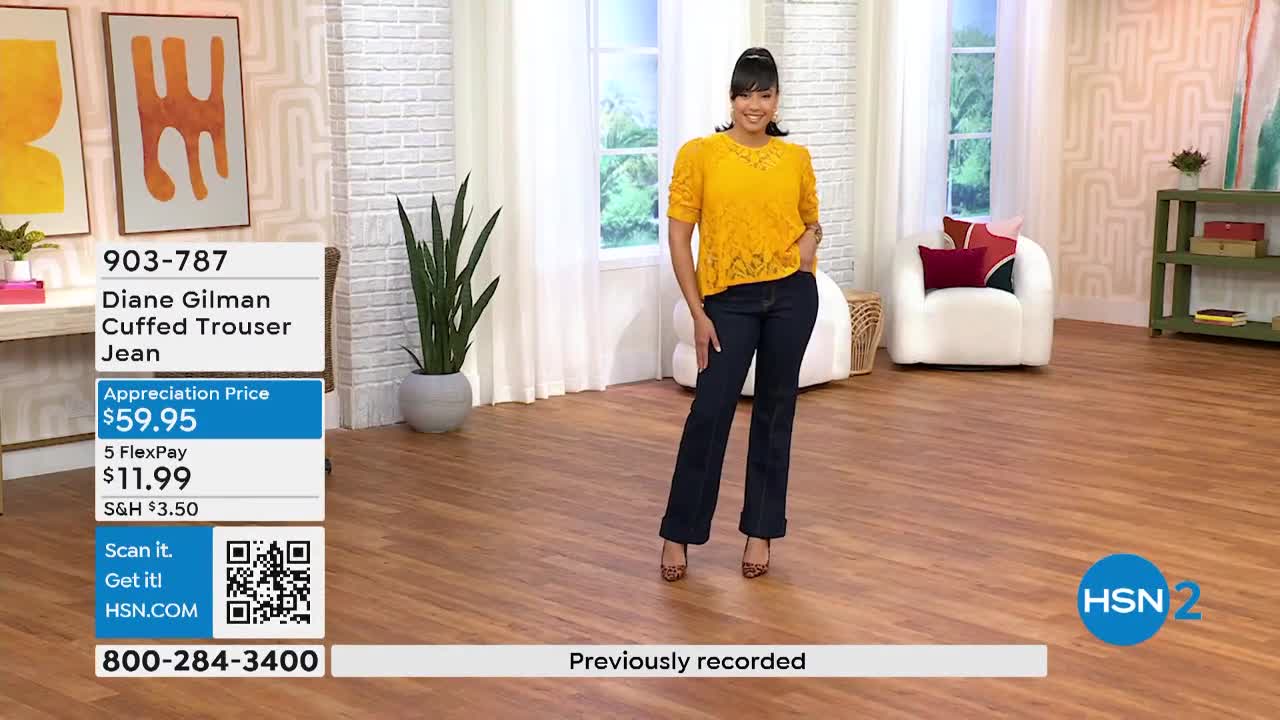 A woman in a yellow top and dark jeans stands in a studio setting, smiling at the camera. The HSN2 logo is visible, and a graphic displays the price of the jeans.
