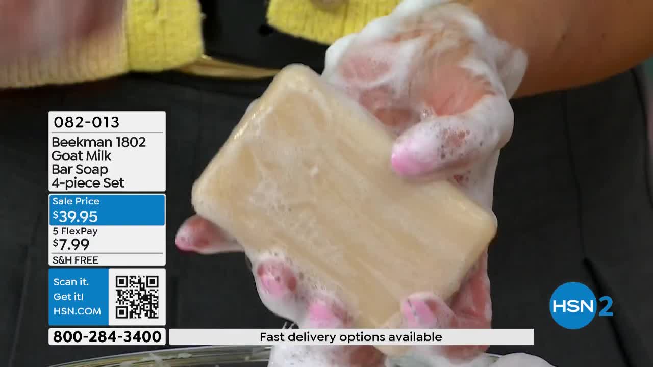 Hands lather a bar of Beekman 1802 Goat Milk soap. The soap is a pale tan color and covered in white foam.