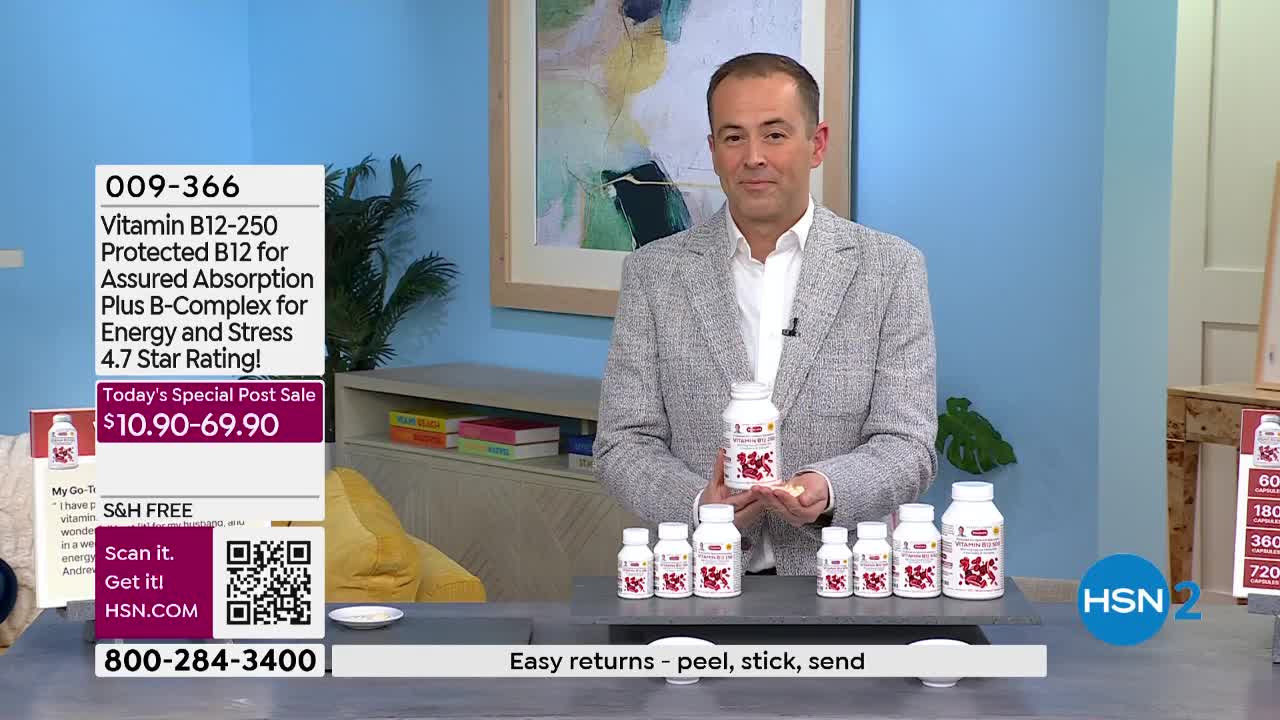 A man in a grey jacket holds a bottle of Vitamin B12-250 and a few pills. Several other bottles of the same supplement are lined up on the counter in front of him.