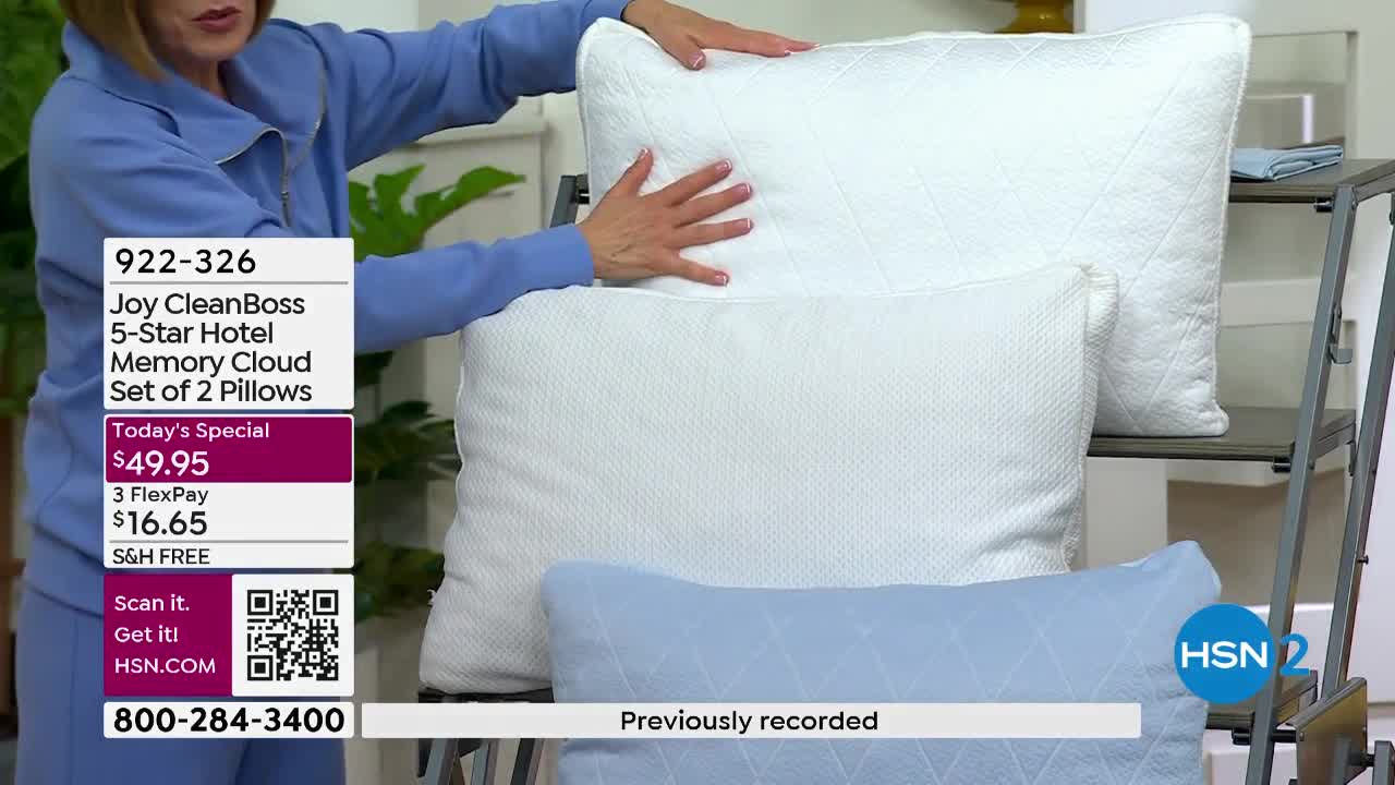 A woman's hands gently press down on a stack of white pillows. Below them, a light blue pillow rests on a shelf.