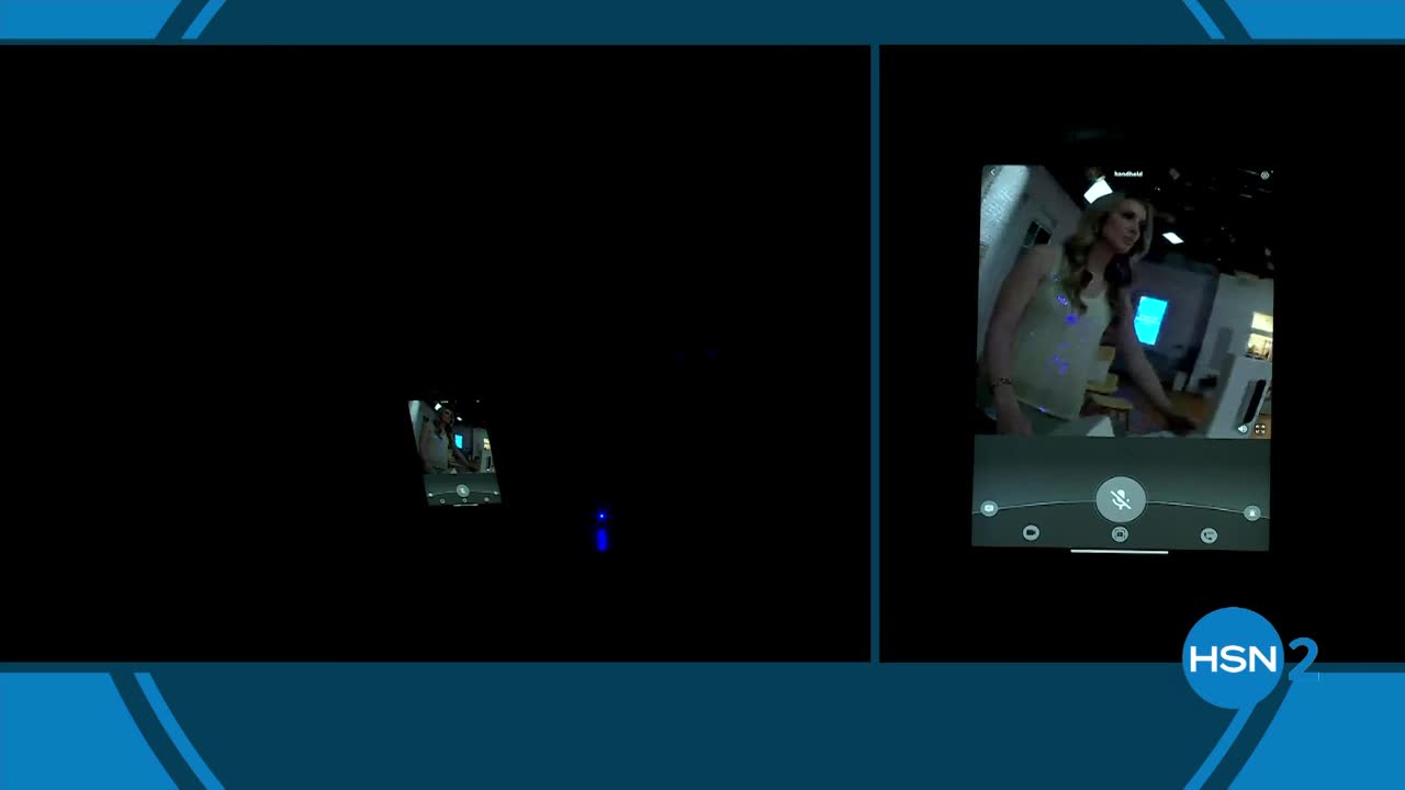 A small, dark object with blue lights moves across the blackness. On the right, a woman in a sparkly top stands in front of a counter.