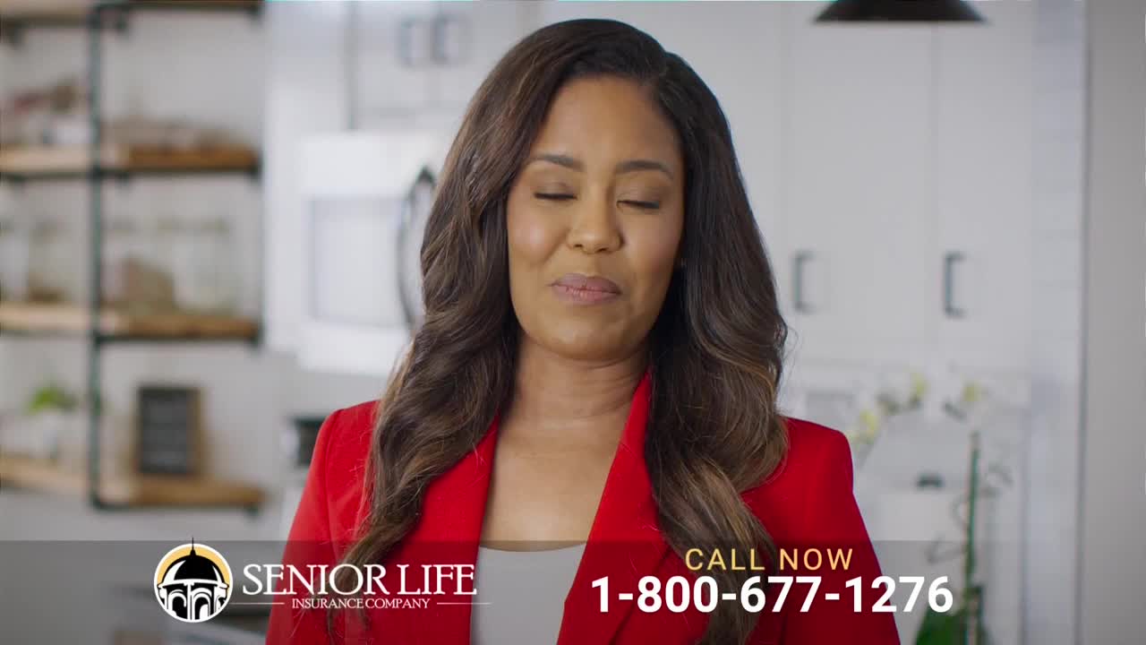 A woman in a red blazer smiles with her eyes closed, appearing relaxed. The Senior Life Insurance Company logo and a phone number are displayed on the screen.
