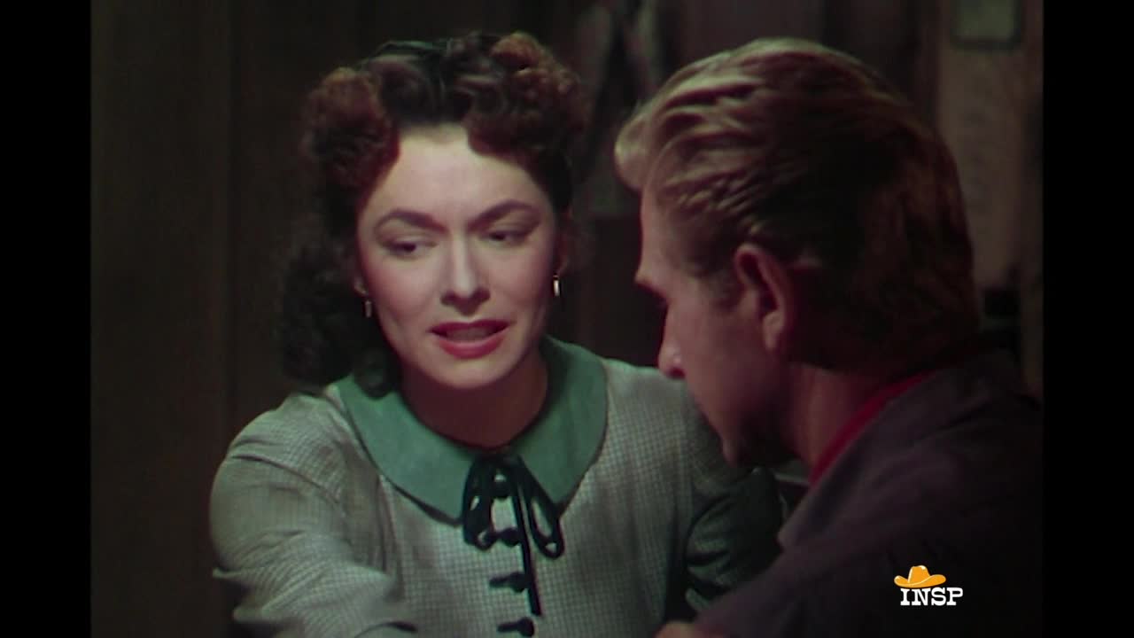 She's leaning forward, her gaze fixed on the man beside her. He's turned away, listening intently to what she has to say.
