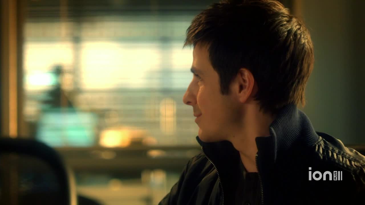 A man in a black jacket looks off to the side, a slight smile playing on his lips. The ION Plus logo is visible in the corner, indicating this is a scene from a show.
