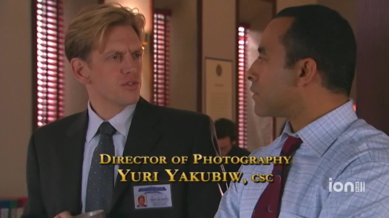 A man in a suit gestures while speaking intently to another man. The ION Plus logo is visible, and the credits for the Director of Photography are displayed on the screen.
