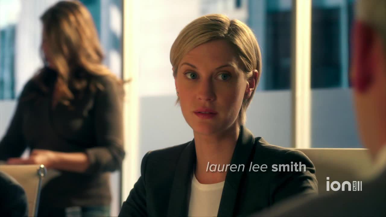 Lauren Lee Smith, in a dark blazer, looks directly ahead with a slight frown. The ION Plus logo is visible in the corner.
