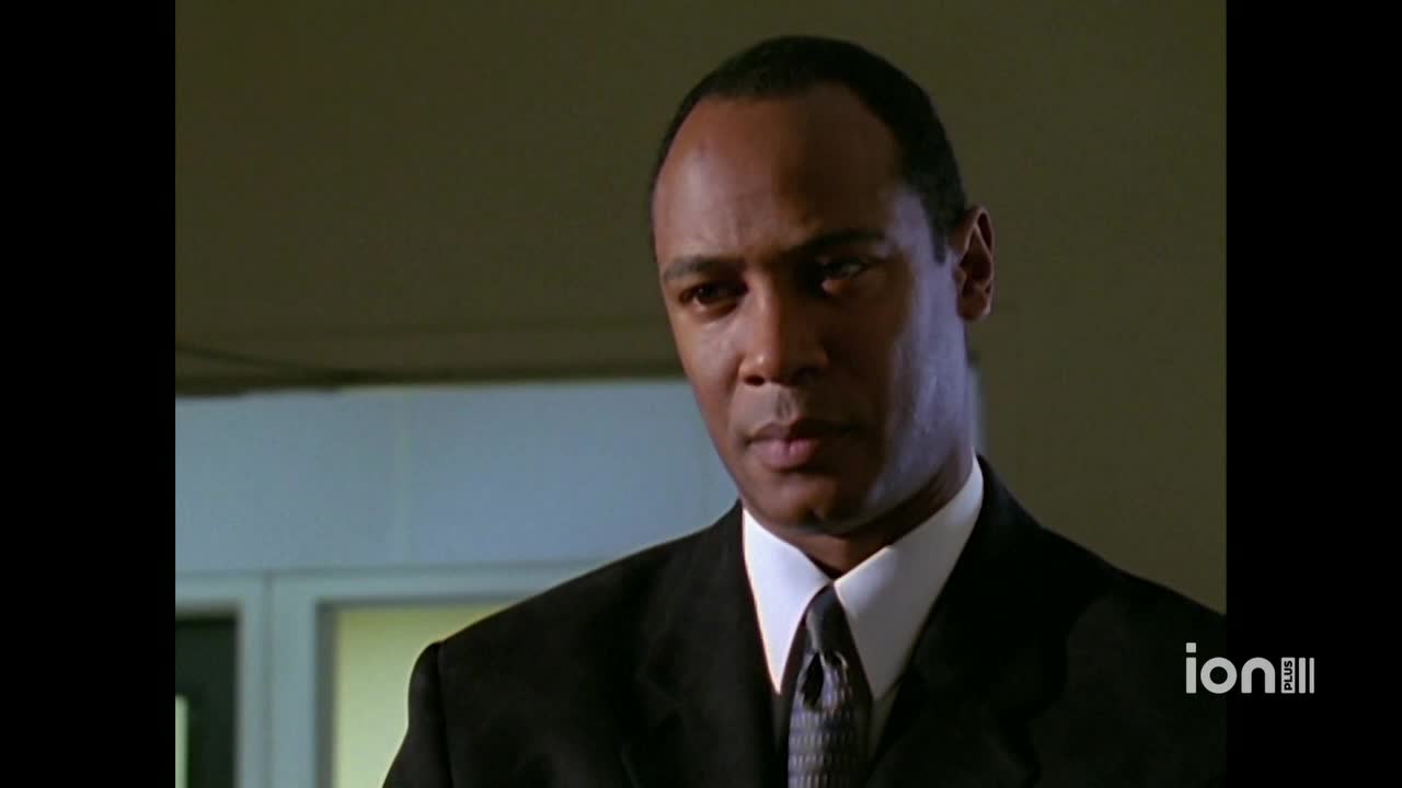 The man in the suit stares directly ahead, his expression unreadable.  A small logo in the corner indicates this is a broadcast on ION Plus in the United States.
