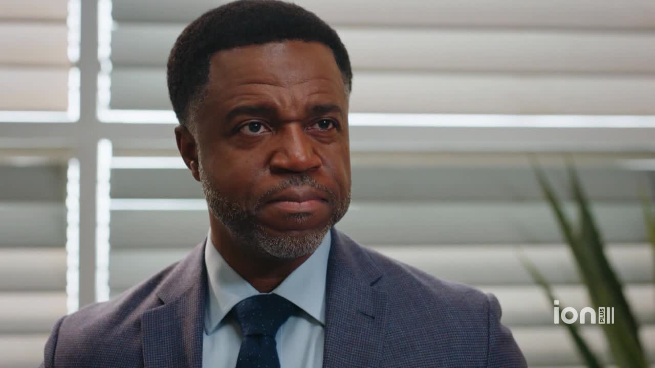 The man in the suit stares intently, his brow furrowed. The ION Plus logo sits in the corner, suggesting a scene from a television show.
