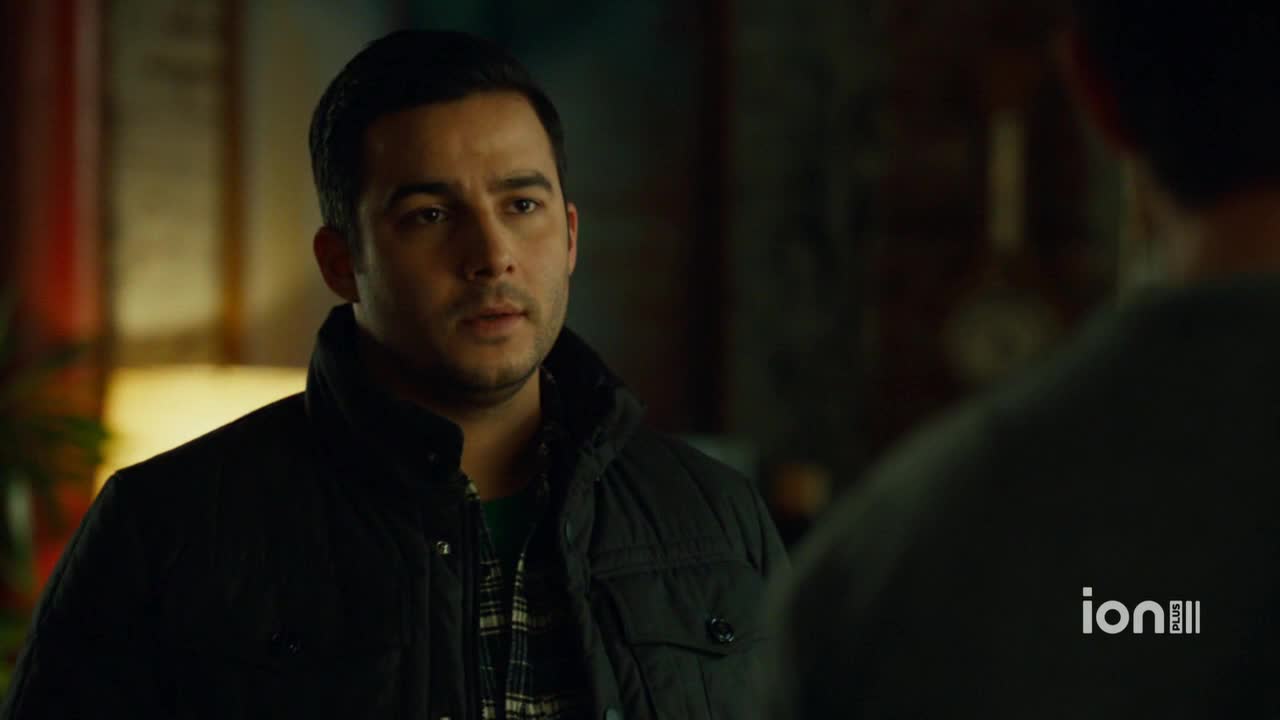 The man in the black jacket is looking intently at someone off-screen. The ION Plus logo is visible in the corner, suggesting this scene is from a television show.
