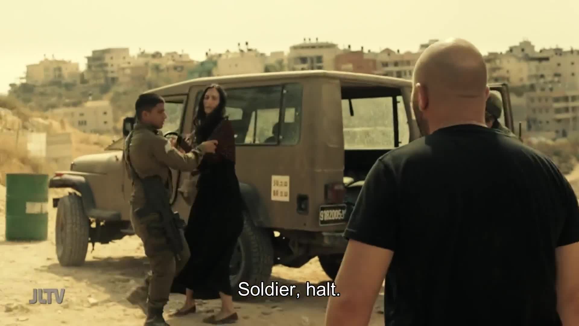 A soldier in uniform is physically restraining a woman near a military jeep. A man in a black shirt is facing them, and the words "Soldier, halt" appear on the screen.
