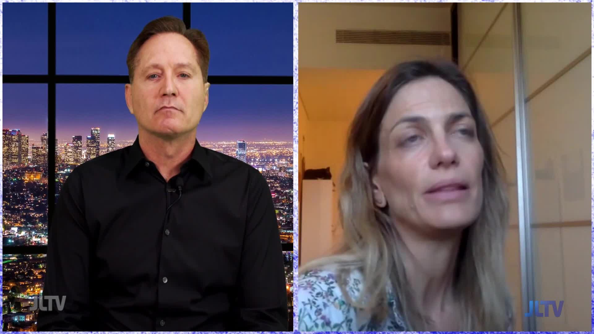 On Jewish Life Television, a man in a black shirt sits in front of a cityscape backdrop, listening intently. Across the screen, a woman with long hair is speaking, her expression serious.

